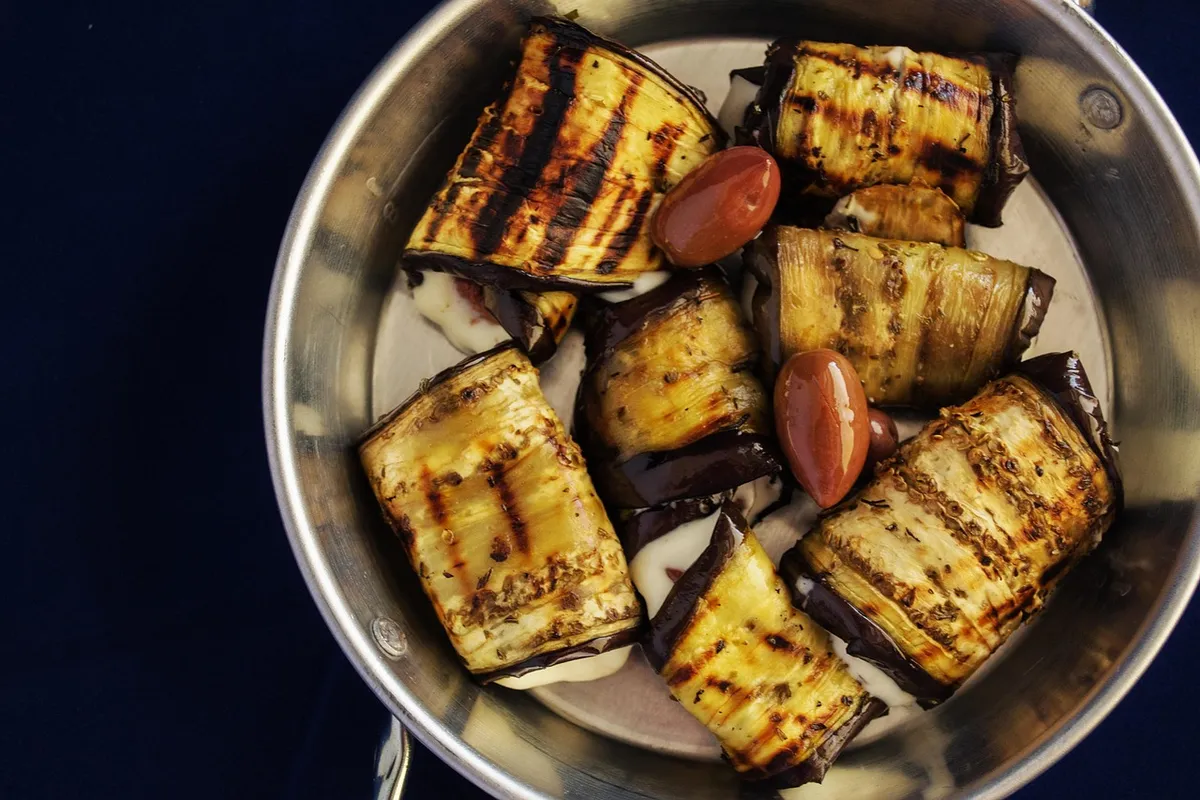 Rollitos de berenjena a la plancha rellenos, servidos en una fuente