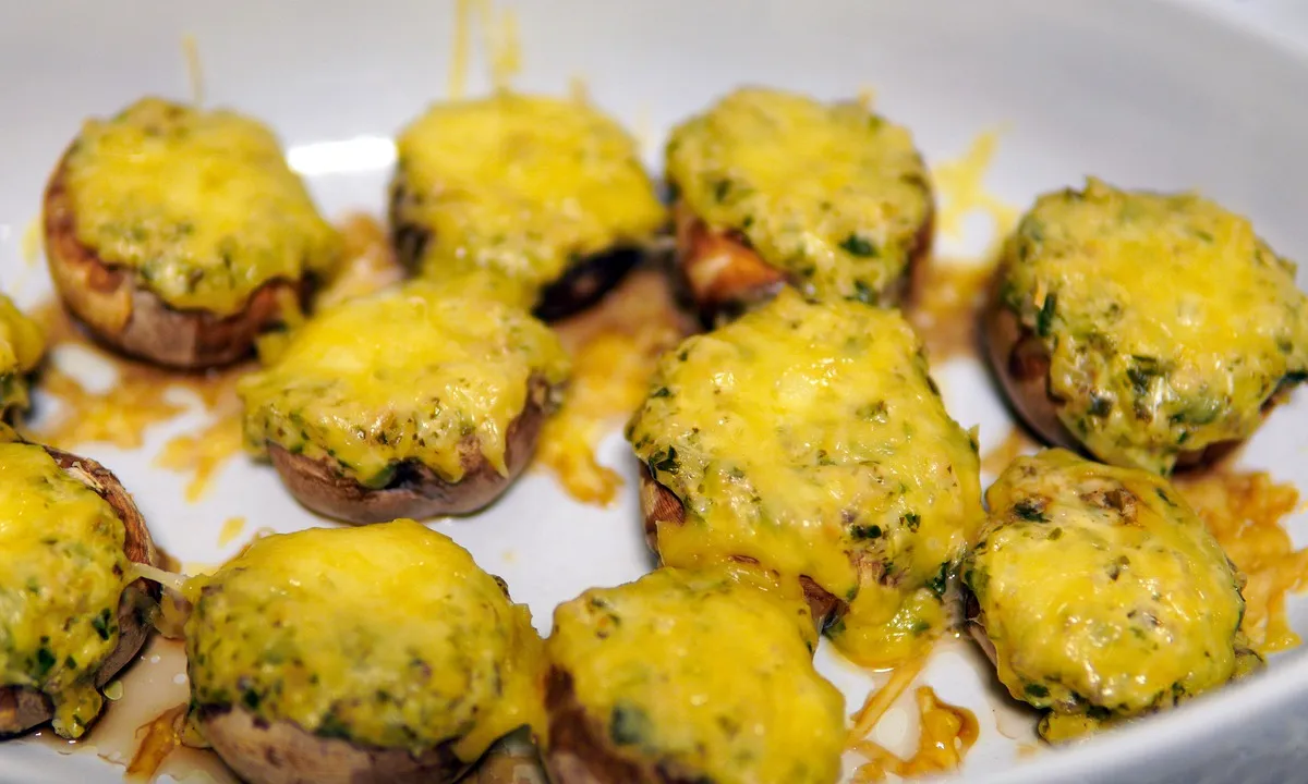Champiñones rellenos de jamón y queso gratinados en una fuente