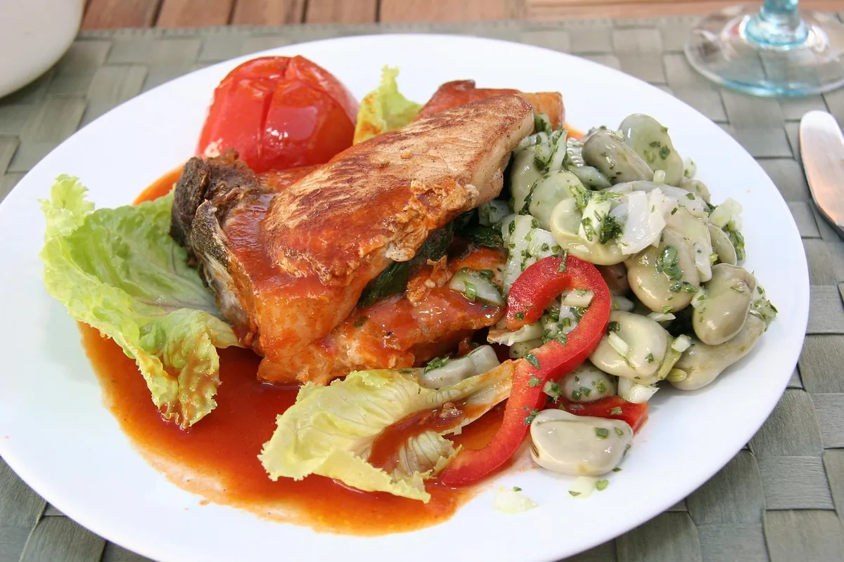 Chuleta de cerdo en salsa de tomate servida con ensalada