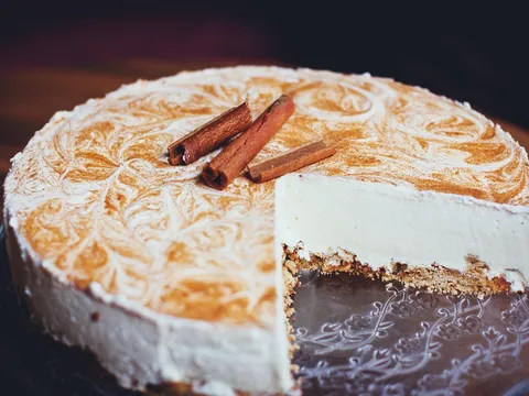 Tarta cremosa de queso con toque de canela, cortada mostrando el interior