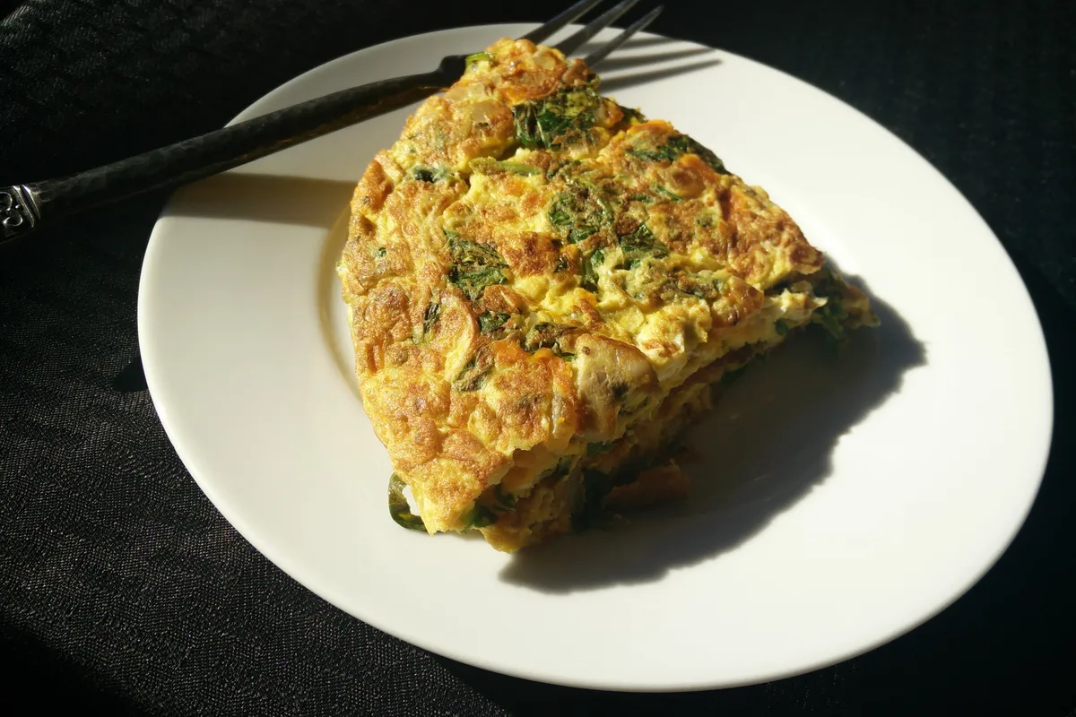 Tortilla de espinacas al horno recién hecha, cortada en porciones
