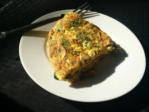 Tortilla de espinacas al horno recién hecha, cortada en porciones