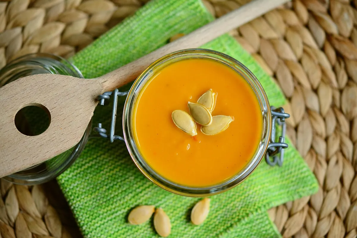 Crema de calabaza y zanahoria servida en un tarro de cristal con pipas